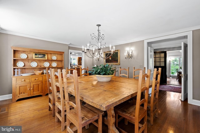 dining space with ornamental molding, light hardwood / wood-style floors, and a notable chandelier