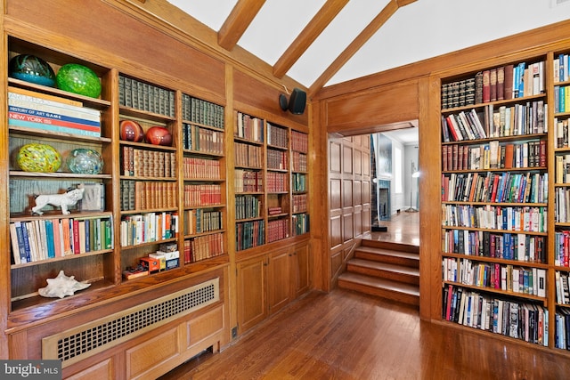 sitting room featuring wooden walls, vaulted ceiling, and hardwood / wood-style flooring