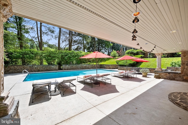 view of swimming pool featuring a yard and a patio area