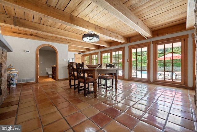 dining area featuring beam ceiling, tile patterned flooring, and wood ceiling