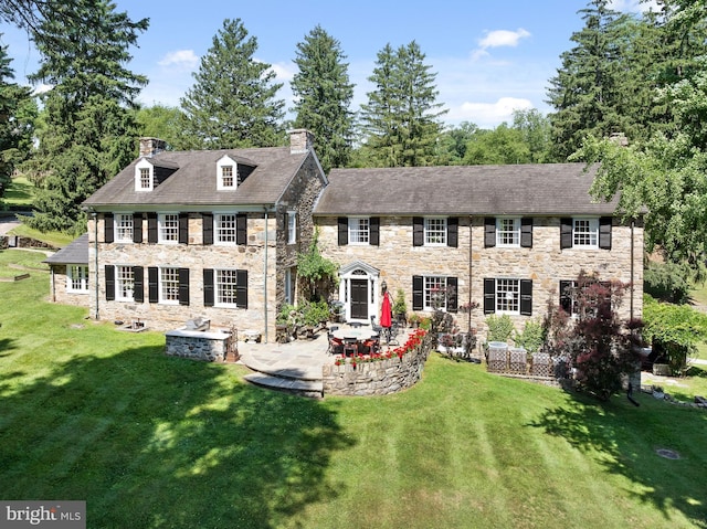 back of property featuring a lawn and a patio area