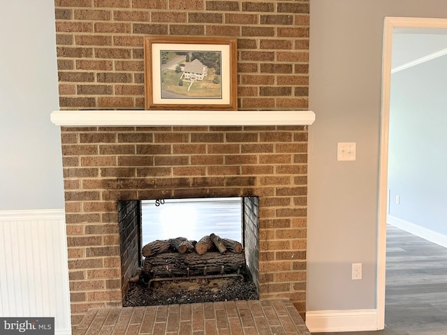 details featuring hardwood / wood-style flooring and a brick fireplace