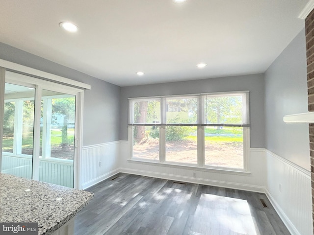 unfurnished dining area with dark wood-type flooring