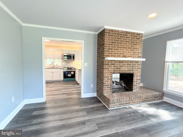 unfurnished living room with a fireplace, dark hardwood / wood-style flooring, and a healthy amount of sunlight