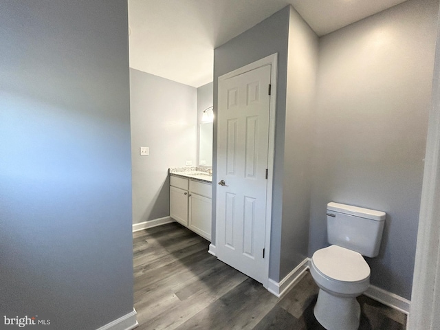 bathroom with hardwood / wood-style floors, vanity, and toilet