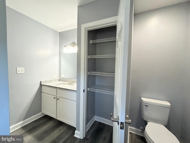 bathroom with hardwood / wood-style floors, vanity, and toilet