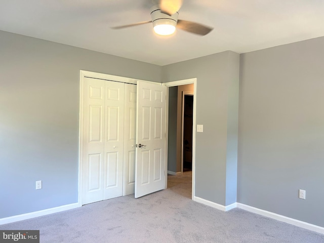 unfurnished bedroom with ceiling fan, light colored carpet, and a closet