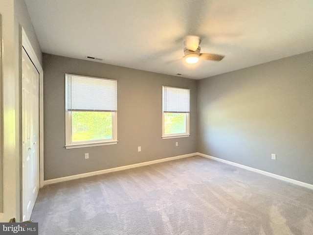 carpeted spare room featuring ceiling fan