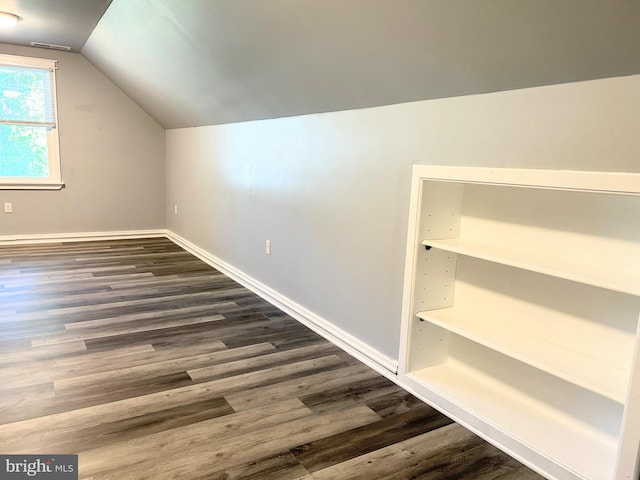 bonus room with dark hardwood / wood-style flooring and vaulted ceiling