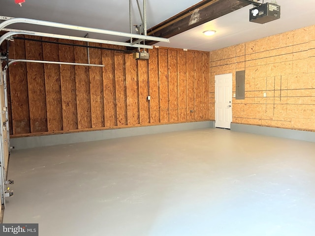 garage with electric panel, wooden walls, and a garage door opener