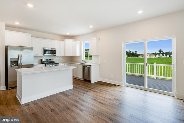 kitchen with white cabinetry, tasteful backsplash, a center island, and appliances with stainless steel finishes