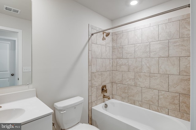 full bathroom featuring tiled shower / bath, vanity, and toilet