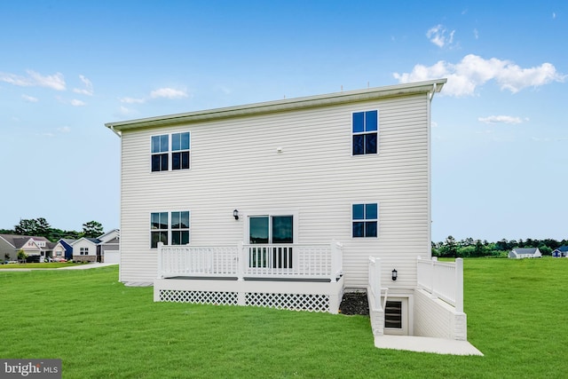 rear view of house featuring a wooden deck and a lawn