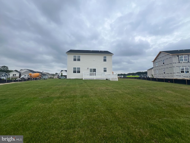 back of house with a wooden deck and a lawn