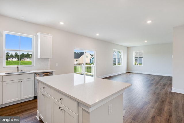 kitchen featuring sink, dark wood-type flooring, white cabinets, and a kitchen island