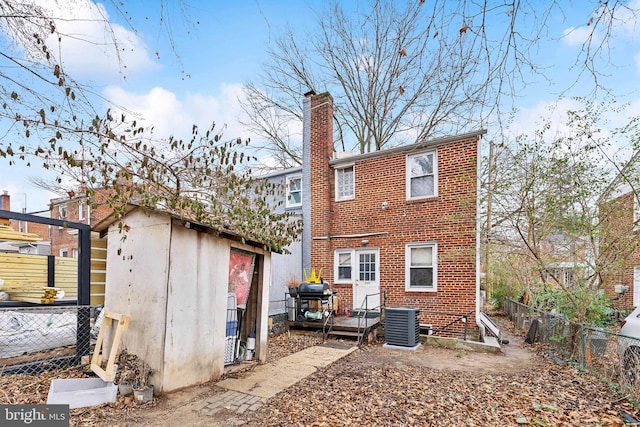 back of property with a shed and central air condition unit