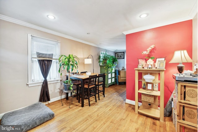 dining space with wood-type flooring and crown molding