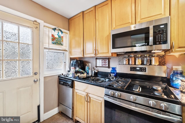 kitchen featuring light brown cabinets, sink, stainless steel appliances, and light tile patterned flooring