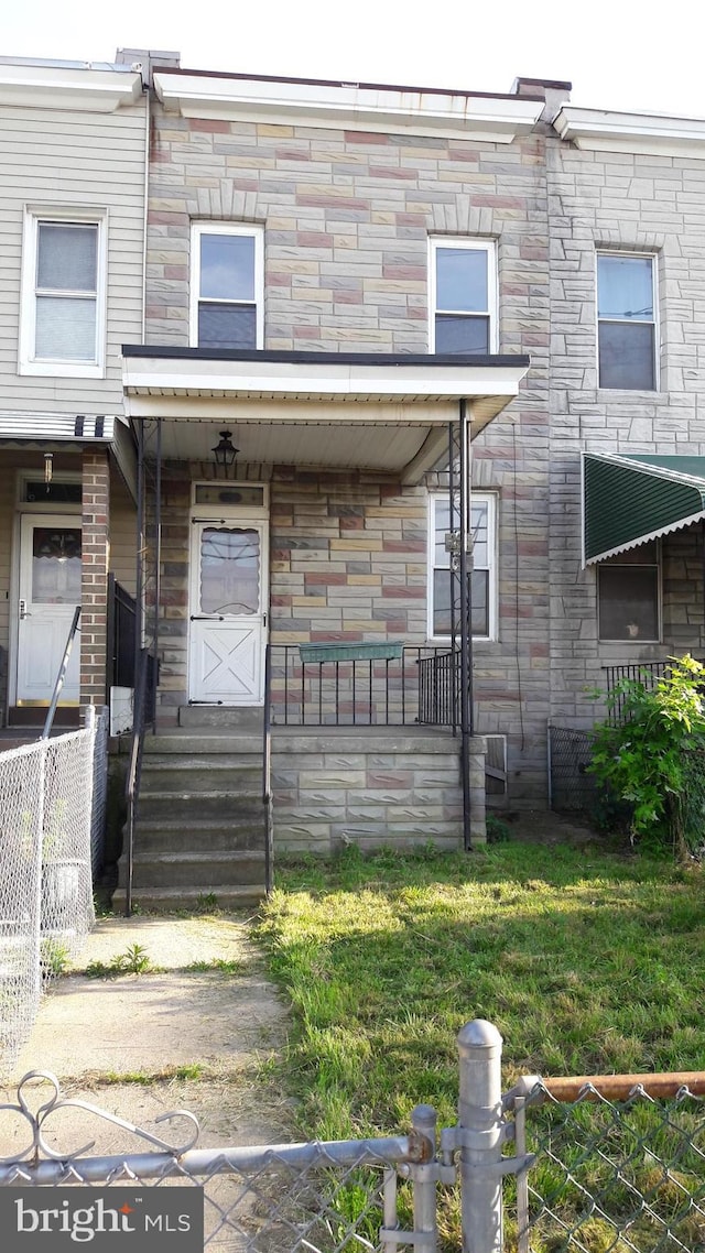 property entrance with a porch and a lawn