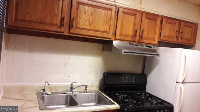 kitchen featuring white fridge, sink, black range with gas cooktop, and exhaust hood