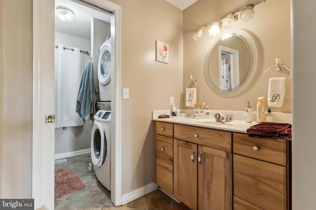 bathroom with tile patterned floors, stacked washer / dryer, and vanity