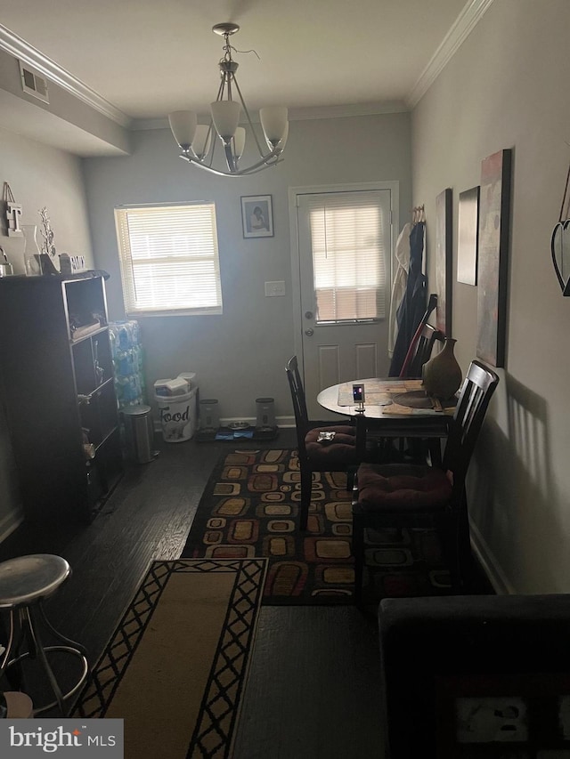 dining space featuring a chandelier, hardwood / wood-style flooring, and crown molding