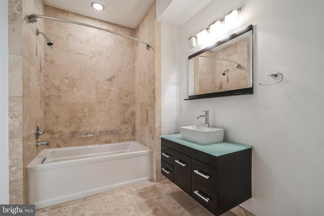 bathroom featuring vanity and tiled shower / bath