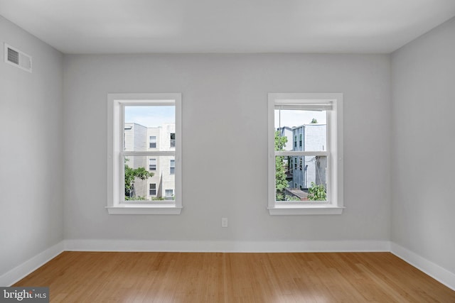 empty room featuring a wealth of natural light and hardwood / wood-style floors