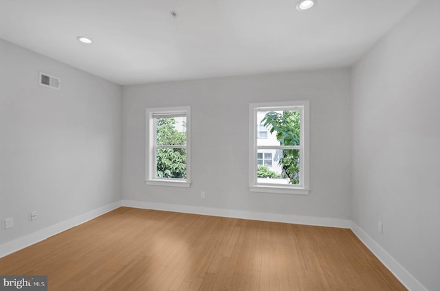 unfurnished room with hardwood / wood-style flooring