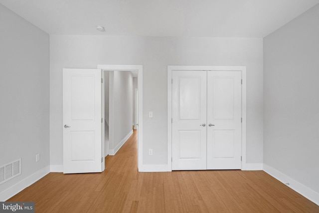 unfurnished bedroom with a closet and light hardwood / wood-style flooring