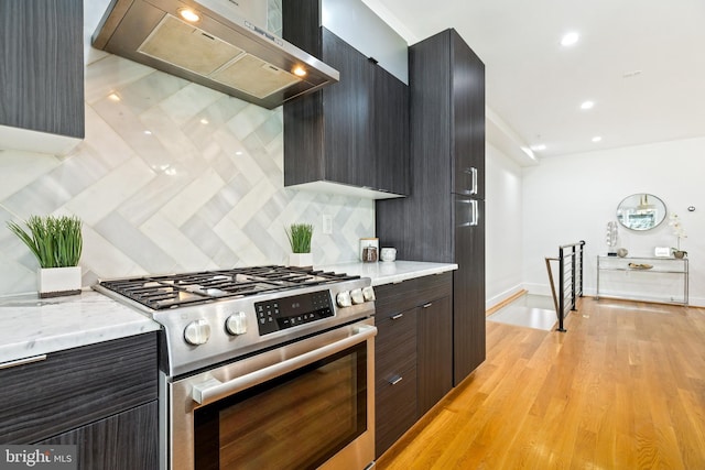 kitchen with sink, stainless steel appliances, an island with sink, pendant lighting, and light hardwood / wood-style floors