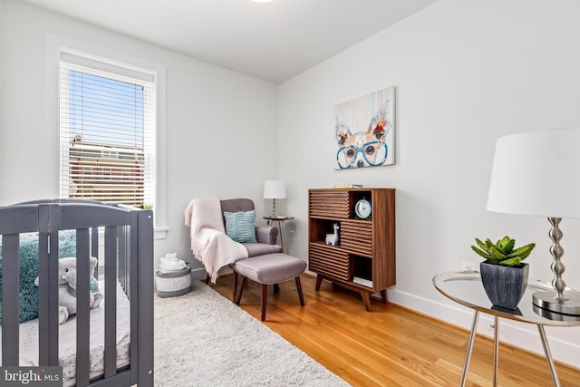 bedroom featuring a crib and wood-type flooring