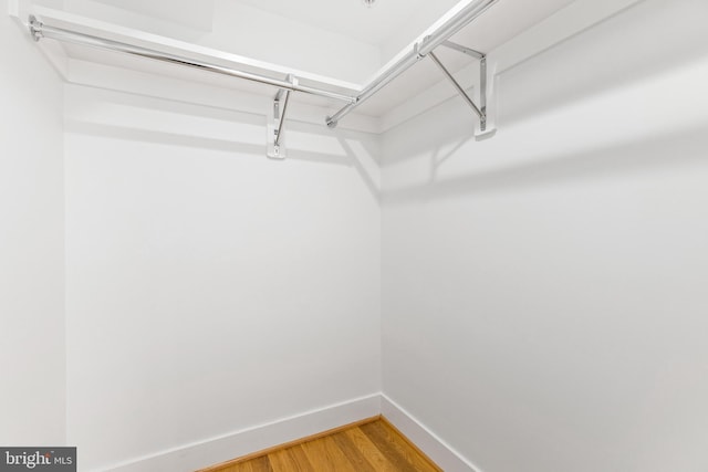 washroom with light hardwood / wood-style floors and stacked washer and clothes dryer