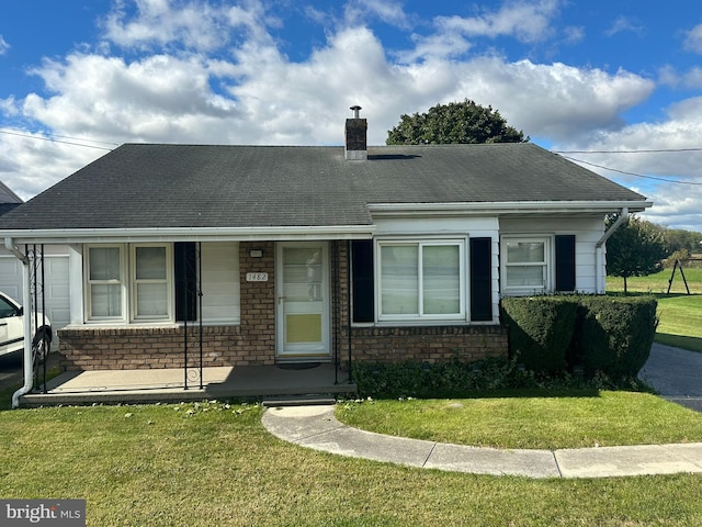 view of front of property with covered porch and a front lawn