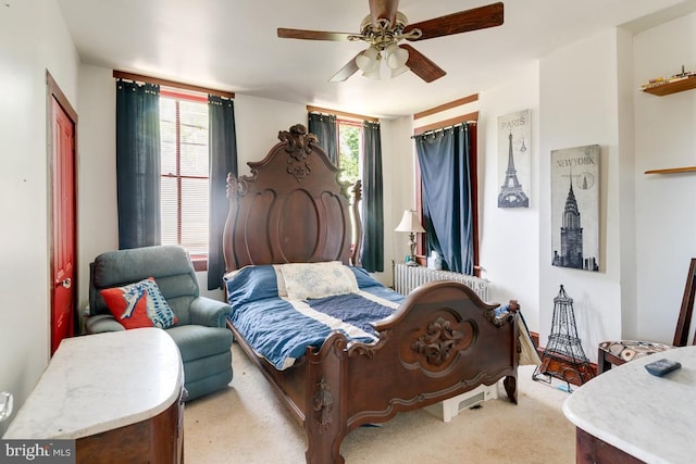 carpeted bedroom with ceiling fan and radiator heating unit