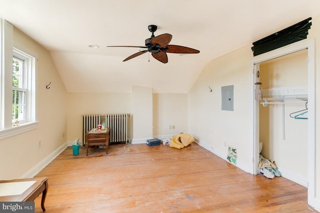 bonus room with radiator, ceiling fan, hardwood / wood-style flooring, electric panel, and lofted ceiling