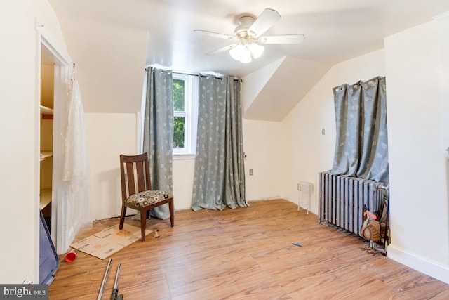 living area featuring radiator, ceiling fan, and light hardwood / wood-style floors