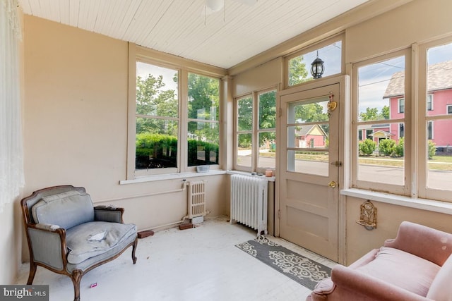 sunroom / solarium featuring radiator and a healthy amount of sunlight