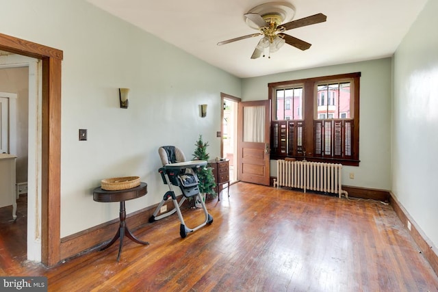 foyer entrance with dark hardwood / wood-style flooring, radiator, and ceiling fan