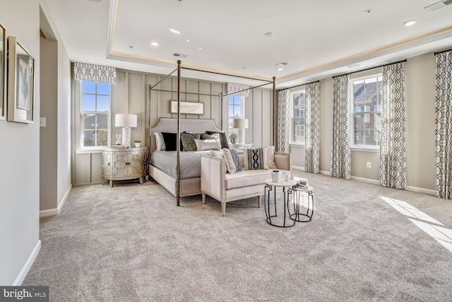 bedroom featuring a tray ceiling and light colored carpet