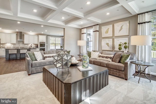 living room with beamed ceiling, light hardwood / wood-style floors, and coffered ceiling