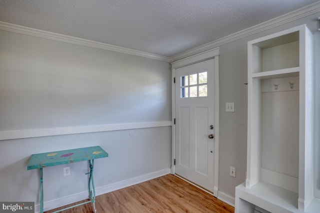 entryway featuring light hardwood / wood-style floors, ornamental molding, and a textured ceiling