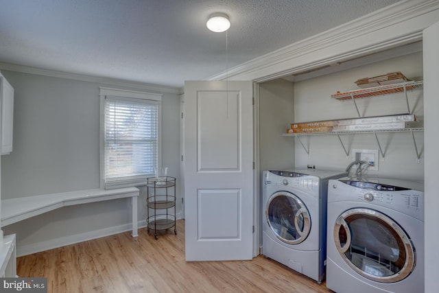 laundry room with washer and dryer, light hardwood / wood-style floors, crown molding, and a textured ceiling