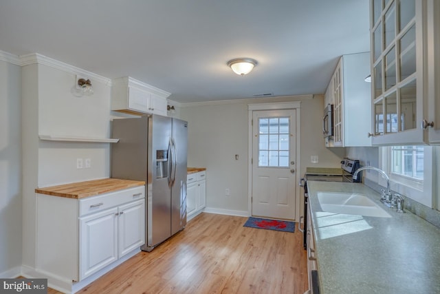 kitchen featuring butcher block countertops, white cabinetry, sink, and appliances with stainless steel finishes