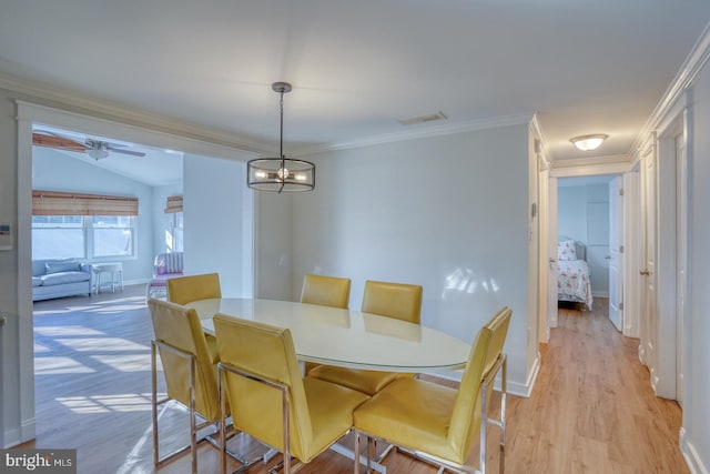 dining area with light wood-type flooring, ceiling fan with notable chandelier, vaulted ceiling, and ornamental molding