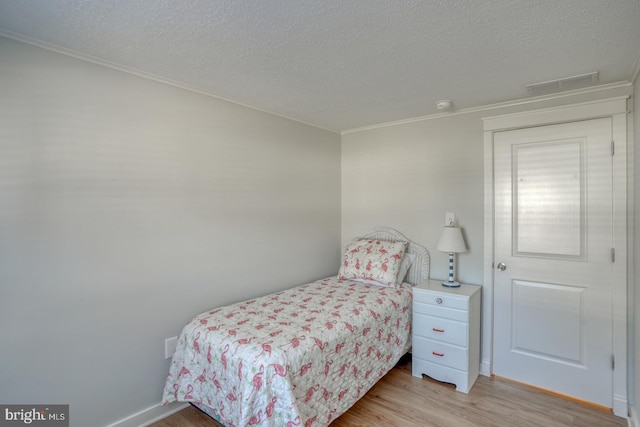 bedroom with a textured ceiling and light hardwood / wood-style flooring