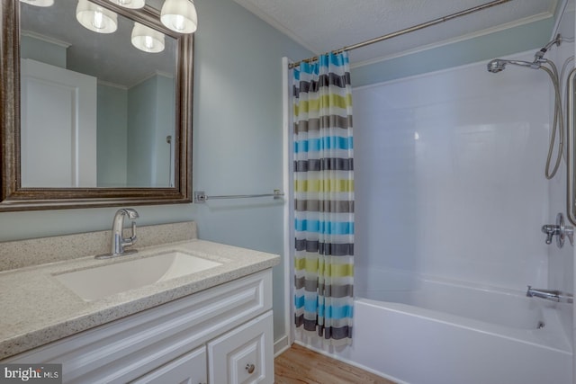 bathroom featuring shower / bathtub combination with curtain, crown molding, hardwood / wood-style floors, a textured ceiling, and vanity