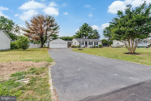 ranch-style home featuring an outbuilding, a front yard, and a garage