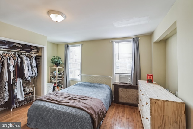 bedroom featuring cooling unit, a closet, and hardwood / wood-style floors