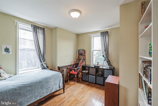 bedroom with light wood-type flooring and multiple windows